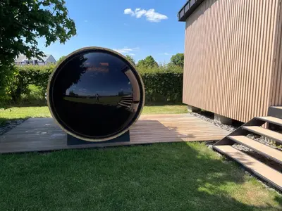 a large round mirror sitting on a wooden deck at Tiny house moderne in Thimister
