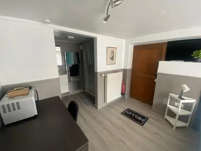 a living room with a table and a door at Route 123 Birchwood Pension in Kortessem