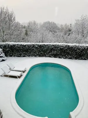 a swimming pool covered in snow in a yard at Au cœur de l'Ardenne Bleue - Studio avec piscine in Baelen