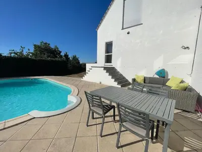 a patio with a table and chairs next to a swimming pool at Au cœur de l'Ardenne Bleue - Studio avec piscine in Baelen