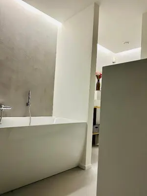 a bathroom with a white tub and a sink at La Bel échappée in Aubel