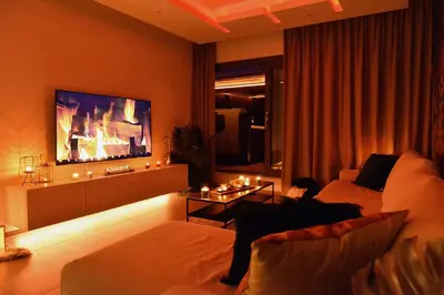 a living room with a couch and a flat screen tv at SuiteDreams-Jungle Suite - Liège in Liège