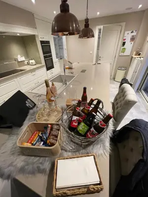 a person sitting on a kitchen counter with bottles of beer at Huys In As in As