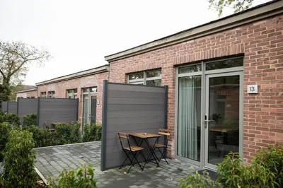 a patio with a table and chairs in front of a brick building at City Housing Genk in Genk
