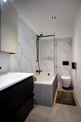 a bathroom with a tub and a sink and a toilet at City Housing Genk in Genk