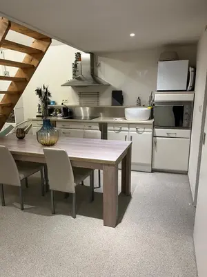 a kitchen with a wooden table and chairs in it at Vakantiehuis de wereldburger Worldcitizen in Oudsbergen