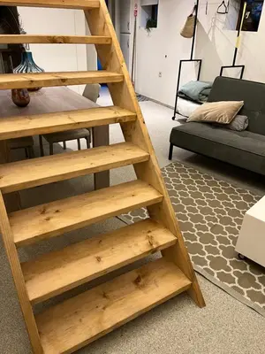 a wooden book shelf in a living room with a couch at Vakantiehuis de wereldburger Worldcitizen in Oudsbergen
