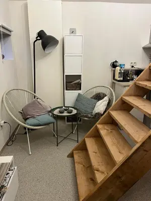 a room with a staircase and a chair and a table at Vakantiehuis de wereldburger Worldcitizen in Oudsbergen