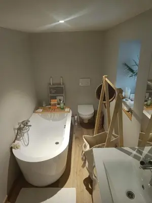 a bathroom with a tub and a toilet and a sink at La maison de Barbara in Aubel