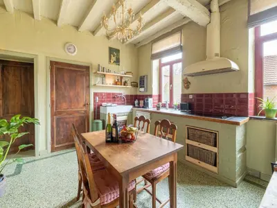 a large kitchen with a wooden table and chairs at Riding School Farm Stay in Sint-Truiden