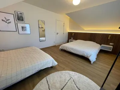 a hotel room with two beds and a mirror at Vakantieappartement Logies Terhagen in Zoutleeuw