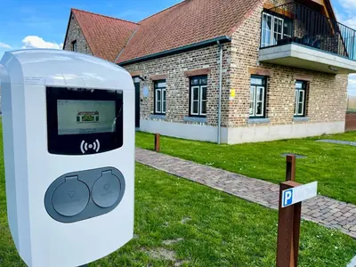 a parking meter in front of a brick building at Vakantieappartement Logies Terhagen in Zoutleeuw