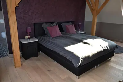 a bedroom with a large bed with two night stands at Hoeve Lavigne in Wellen