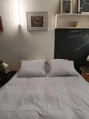 a bed with two pillows on it in a room at Loft, parking privé, terrasse, entrée indépendante in Liège