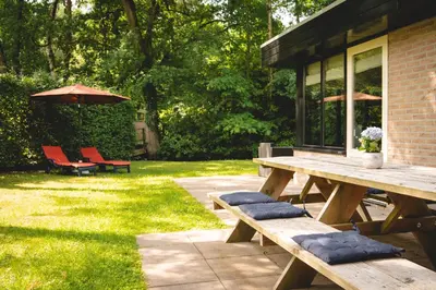 a picnic table with two chairs and an umbrella at Boshuisje Rekem - Rivus in Lanaken