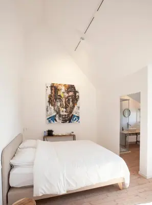 a bedroom with a bed and a painting on the wall at Le Charbonnage in Genk