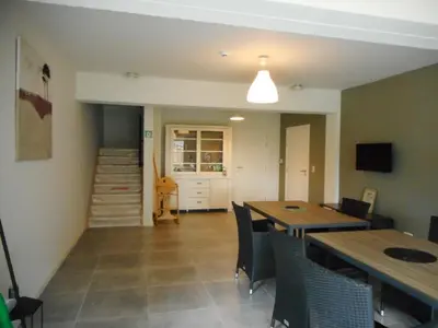 a dining room with tables and chairs and a staircase at De Hoog Velden 12 in Pelt