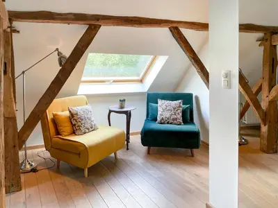 a living room with two chairs and a window at B&B De Paenhoeve in Eksel