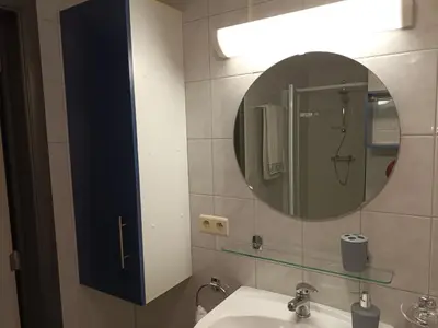 a bathroom with a mirror and a sink at Kanaalzicht21 in Hasselt