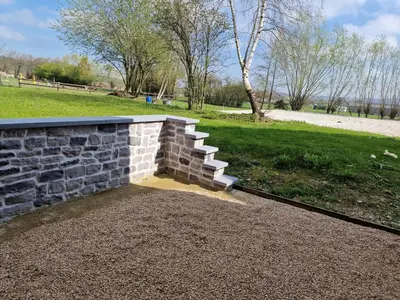 a brick retaining wall with stairs in a park at Gîte Eschen in Plombières