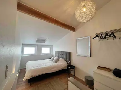 a bedroom with a bed and a chandelier at Grand Triplex d'architecte en hypercentre in Liège