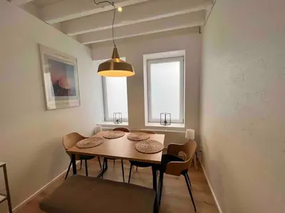 a dining room table with chairs and aendant light at Grand Triplex d'architecte en hypercentre in Liège