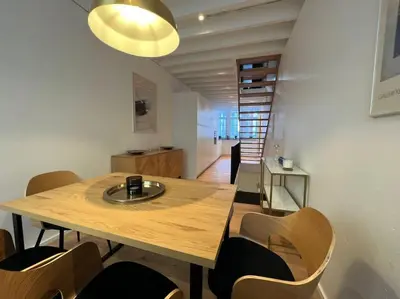 a dining room with a wooden table and chairs at Grand Triplex d'architecte en hypercentre in Liège