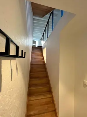a staircase with wooden floors and white walls at Grand Triplex d'architecte en hypercentre in Liège