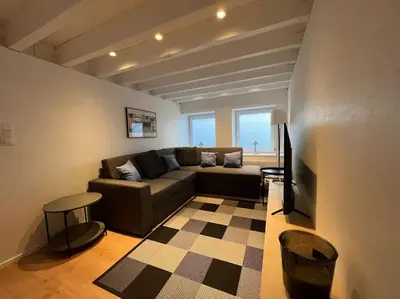 a living room with a couch and a table at Grand Triplex d'architecte en hypercentre in Liège