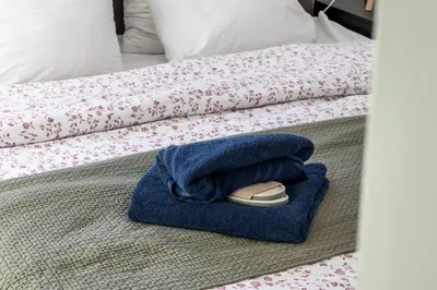 a bed with a towel and a shoe on it at Penthouse Hors-Château in Liège
