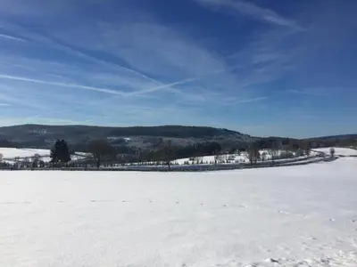 a field covered in snow with a blue sky at Verviers Villa with Sauna in Verviers