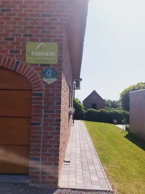 a brick building with a sign on the side of it at Ô Baguenaudes in Jalhay