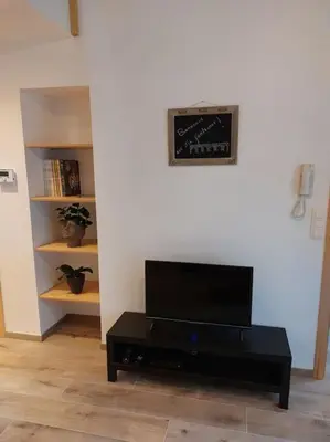 a living room with a tv and a black coffee table at Aux six fontaines in Herve