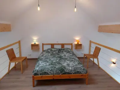 a bedroom with a bed with two chairs and lights at Aux six fontaines in Herve
