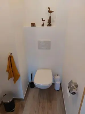 a white bathroom with a toilet and a sink at Aux six fontaines in Herve