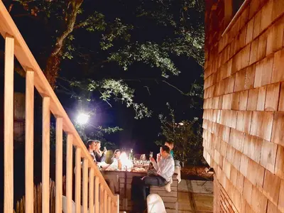 a group of people sitting at a table at night at Lodge op de Berg in Bree
