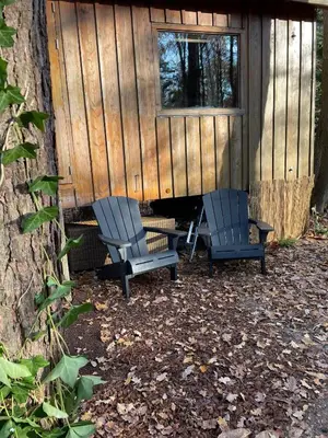 two chairs and a table in front of a cabin at Pipowagen de Kat in de Hoge Kempen nabij Maastricht in Lanaken
