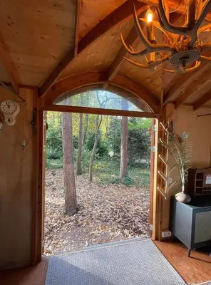 an open door into a cabin with a wood ceiling at Pipowagen de Kat in de Hoge Kempen nabij Maastricht in Lanaken