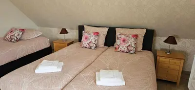 two twin beds in a room with two lamps at B&B Pippa in Peer