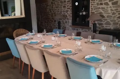 a long table with blue and white plates and glasses at Country house Clos des hortensias in Blégny