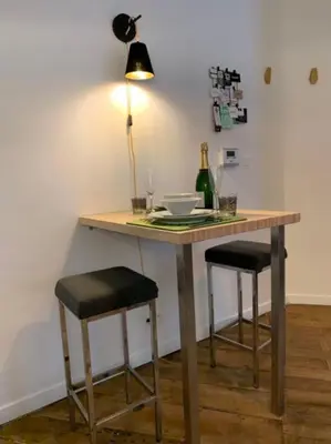 a table with two stools and a table with a lamp at Mr White's in Liège
