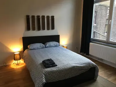 a bedroom with a bed with a black bag on it at Magnifique appartement 1ch en Outremeuse in Liège