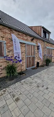 a brick building with two umbrellas in front of it at Logies Op 't Gestel in Oudsbergen