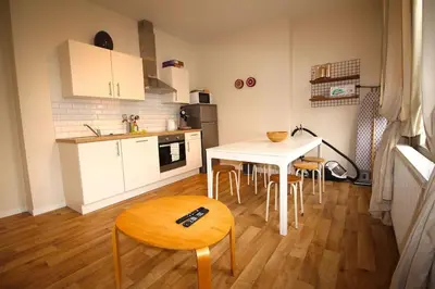 a kitchen with a table and some chairs and a table and a table at Duplex de 3 chambres en plein centre ville - 82/3A in Liège