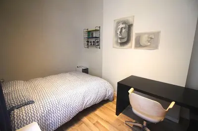 a bedroom with a bed and a desk and a chair at Bel appartement 2 chambres avec terrasse in Liège