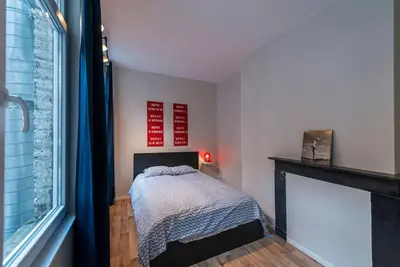 a bedroom with a bed next to a fireplace at Joli appartement 2 chambres à Liège in Liège