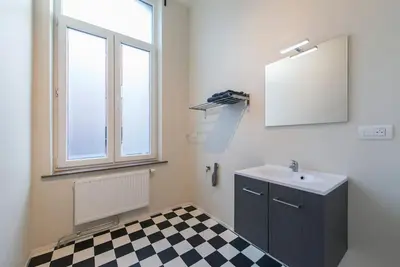 a bathroom with a sink and a checkered floor at Joli appartement 2 chambres à Liège in Liège