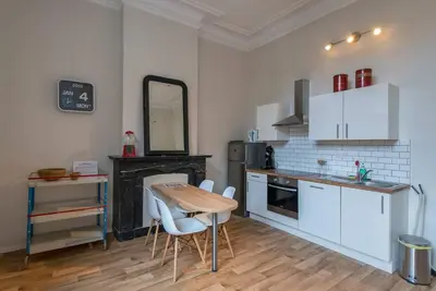 a kitchen with a table and chairs in a room at Joli appartement 2 chambres à Liège in Liège