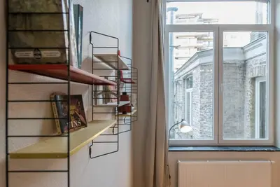 a room with a book shelf next to a window at Joli appartement 2 chambres à Liège in Liège