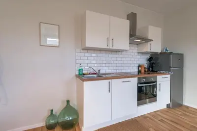 a kitchen with white cabinets and a sink at Appartement 4 chambres à Liège in Liège